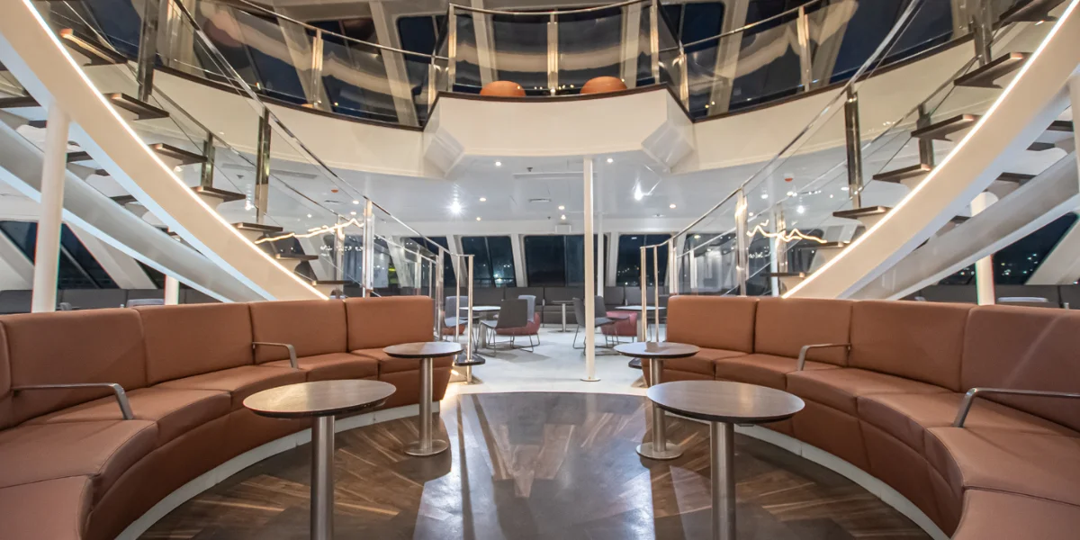 Salón interior del ferry Buenavista Express con escalinata y mesas interiores