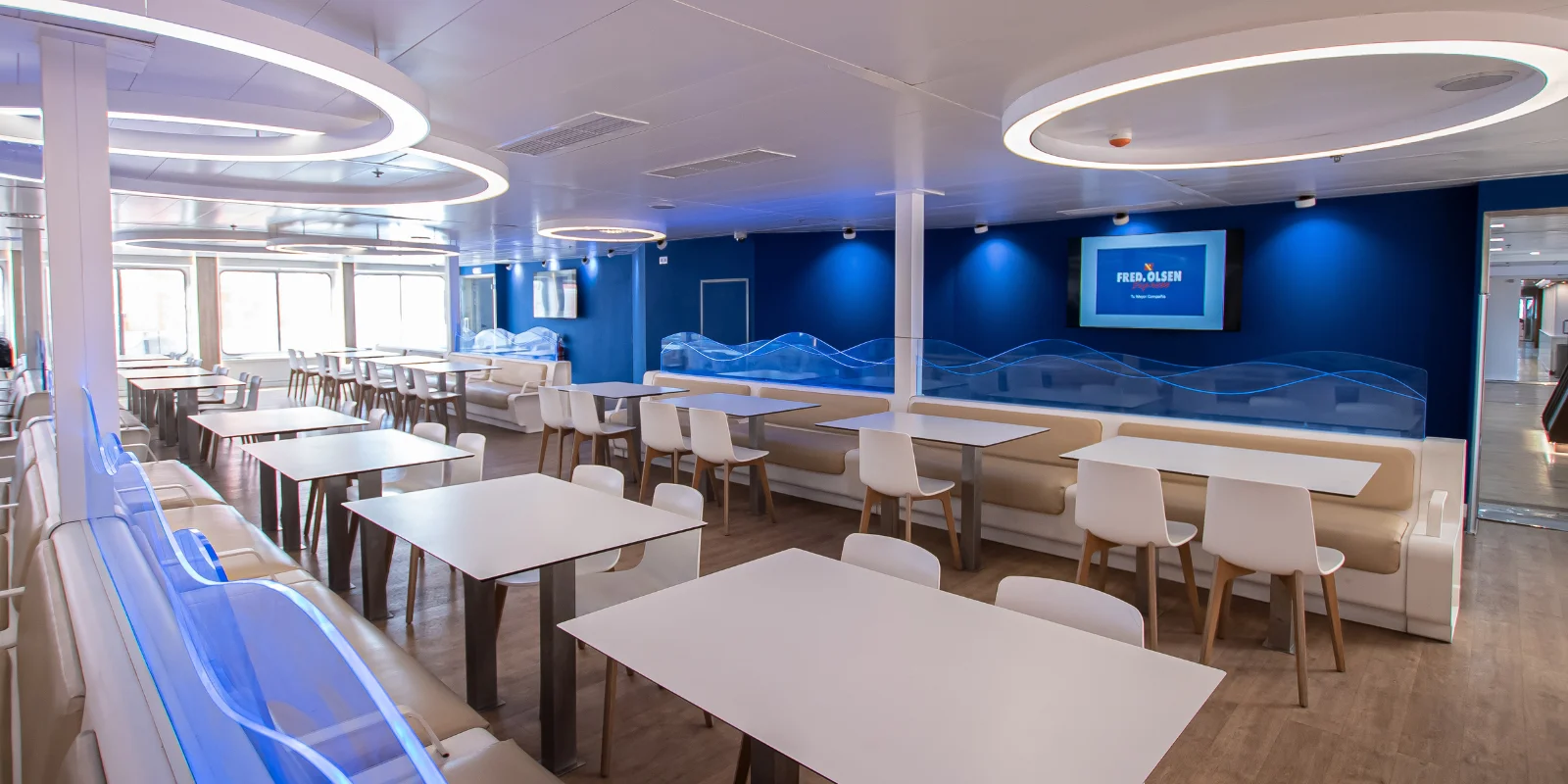 Zonas de descanso con mesas y sillas dentro del ferry Buenavista Express