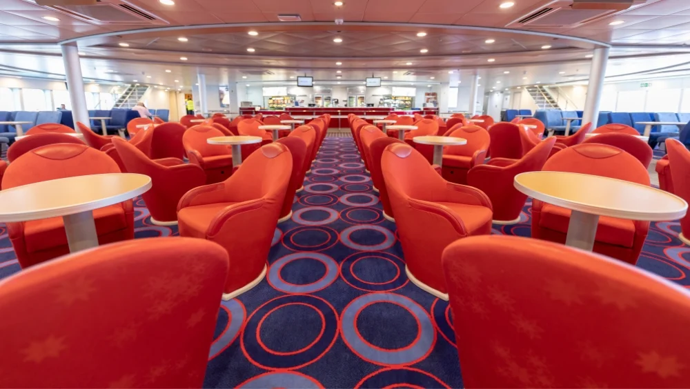 Bentago Express interior lounge with tables and chairs, and the cafeteria in the background