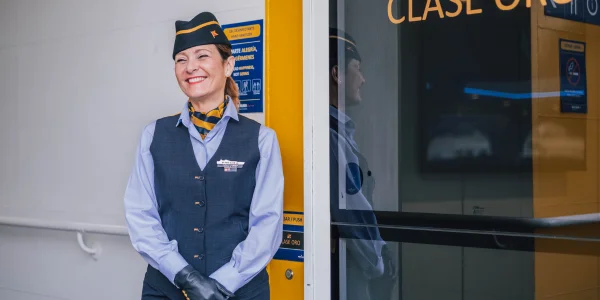 Tripulación de cabina frente a la entrada de la clase oro de un barco de Fred. Olsen Express