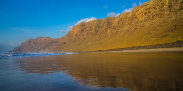 Playa de Famara con acantilados y mar de Lanzarote al atardecer