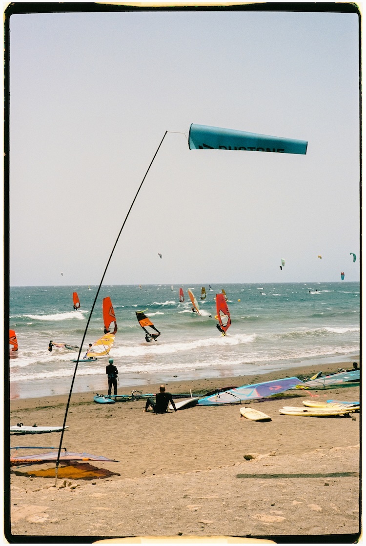 Playa de El Médano en Tenerife con surfistas, viento y paisaje volcánico.