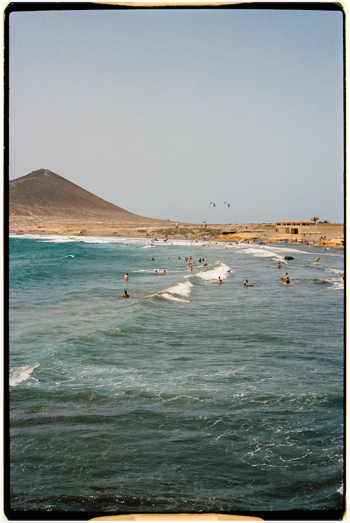 Playa de El Médano en Tenerife con personas relajándose junto al mar.