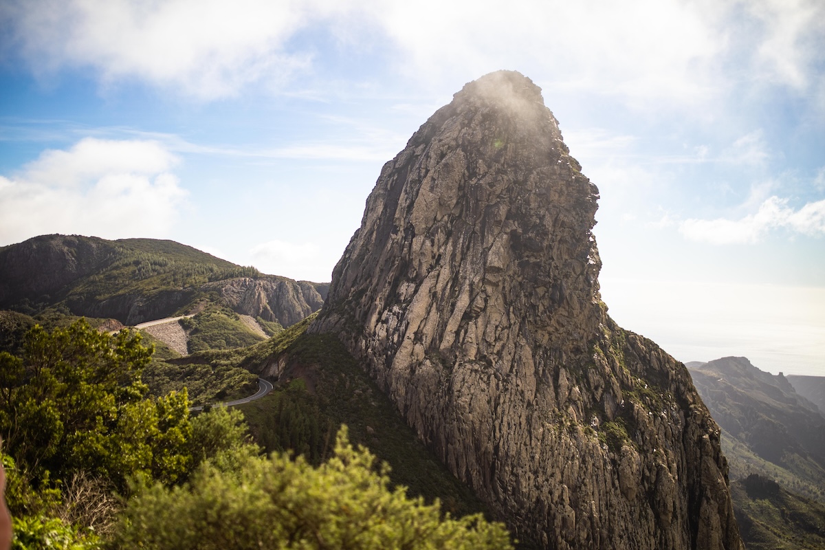 Formación rocosa en la cima de La Gomera rodeada de bosque de laurisilva con vistas amplias y cielo parcialmente cubierto.