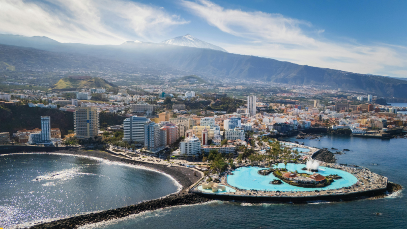 Vista del Lago Martiánez en Puerto de la Cruz, Tenerife, con piscinas, esculturas y jardines frente al mar.