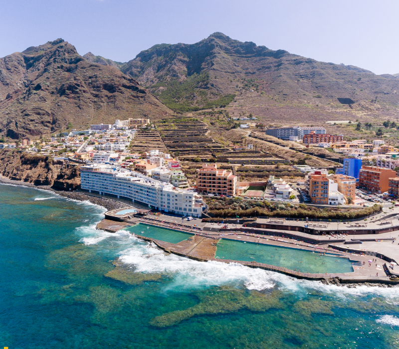 Piscinas naturales en Puerto de la Cruz, Tenerife, con agua de mar, formaciones volcánicas y vistas al océano Atlántico.