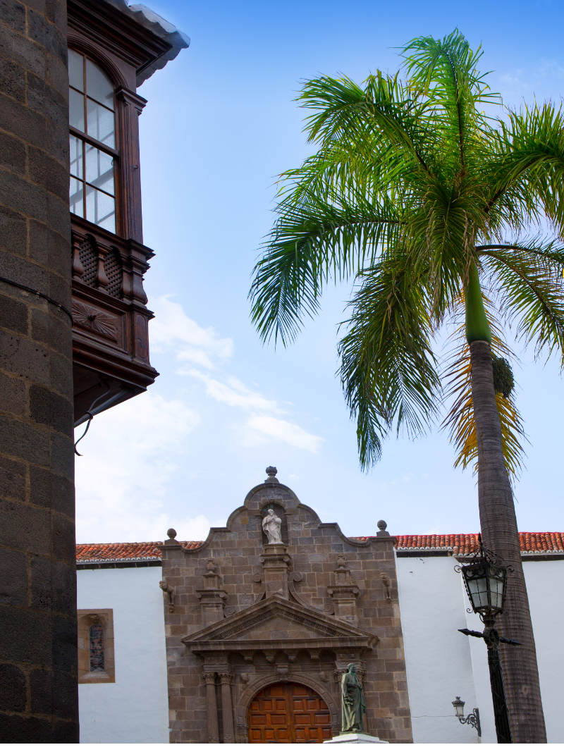 Plaza de España en Santa Cruz de La Palma con la iglesia de El Salvador al fondo, palmeras y arquitectura colonial.