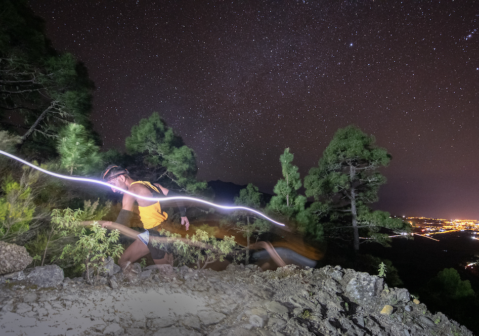Atleta en medio de la Subida a las Estrellas con el paisaje estrellado de El Paso, La Palma