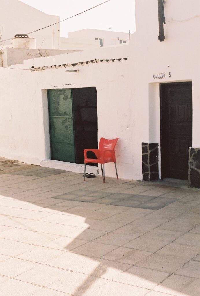 Entrada de una casa en La Caleta de Famara con una silla roja de plástico