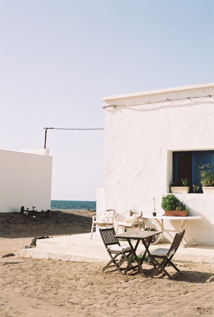 Rincón de descanso en La Caleta de Famara con unas mesas y sillas bajo el sol