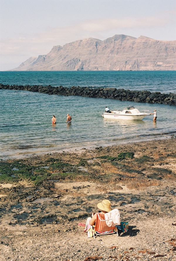 Playa con barquito y los acantilados de Famara al fondo
