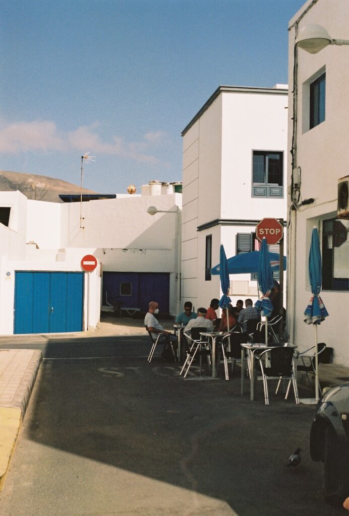 Escena costumbrista en el pueblo de La Caleta de Famara con un grupo de personas en una terraza