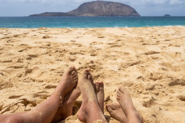 Pies de una familia en la playa de Las Conchas en La Graciosa
