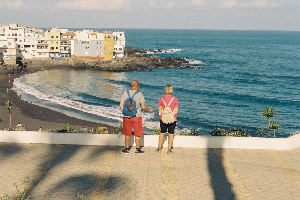 Dos visitantes observando Playa Jardín en Puerto de la Cruz
