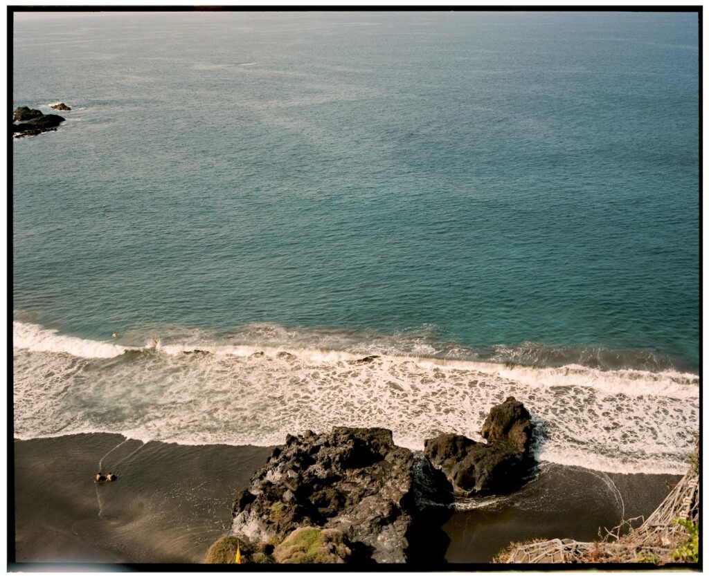 Vista aérea de cala en Canarias con arena negra y el mar azul del Atlántico