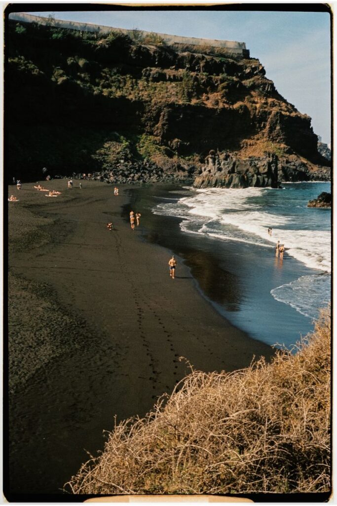 Bañistas en una cala de arena negra en Canarias
