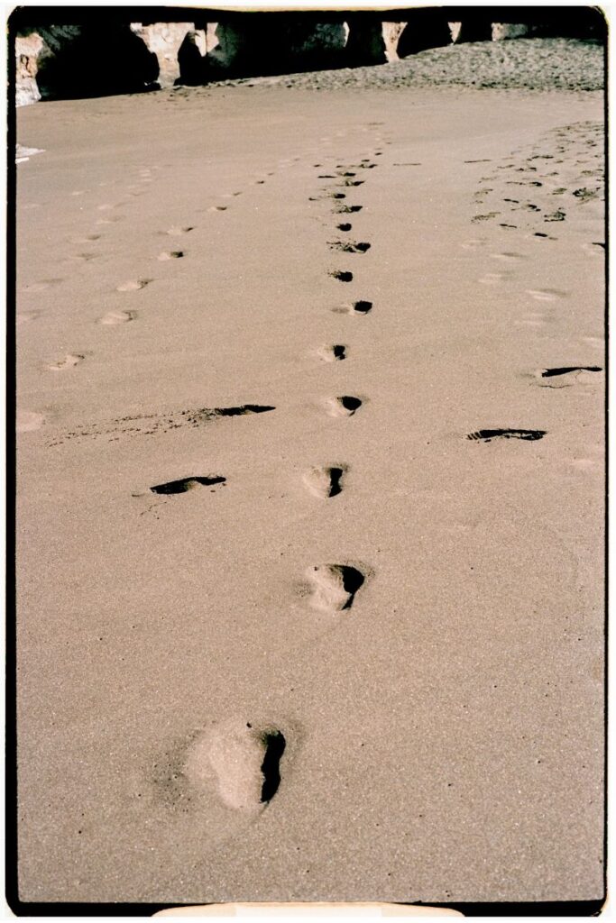 Huellas de pisadas en la arena marrón de una playa canaria