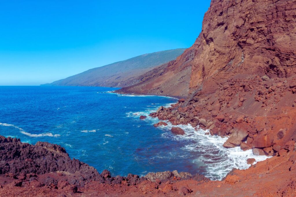 Cala de Tacorón. Acantilado color rojo frente al Océano Atlántico azul