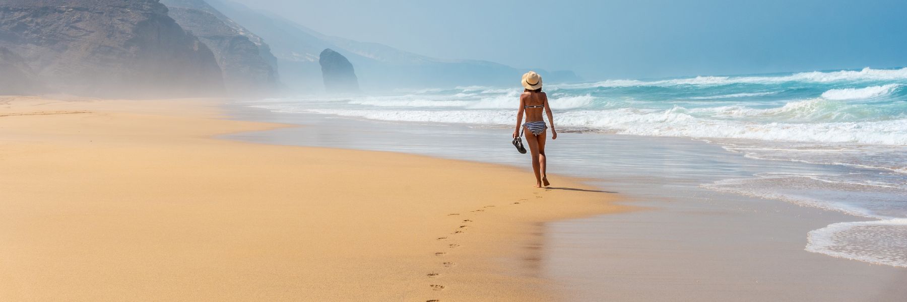 Chica caminando en playa de Canarias